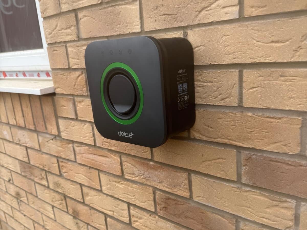 Home EV charger fitted on a brick wall